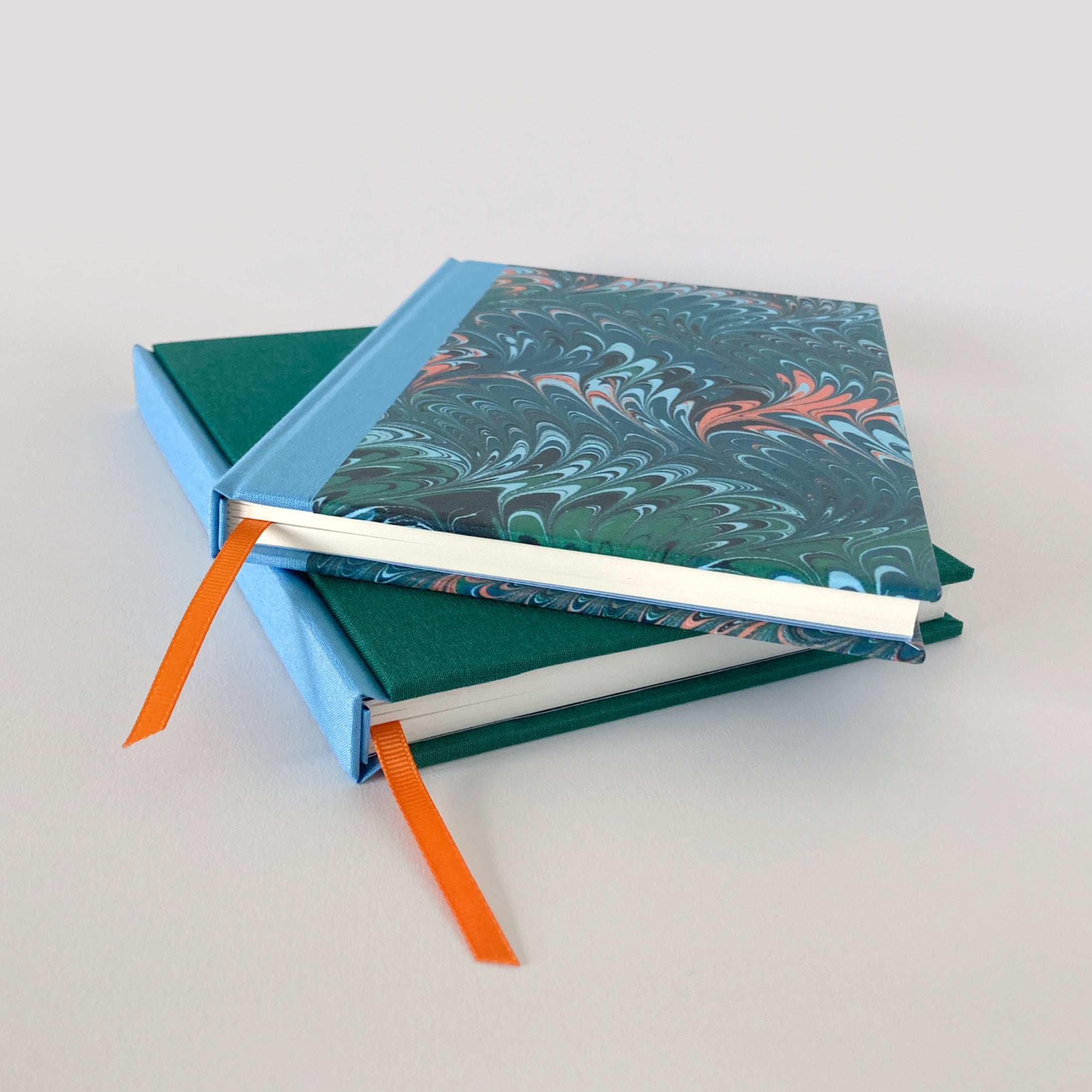 Green and blue clothbound sketchbook with green marble notebook.