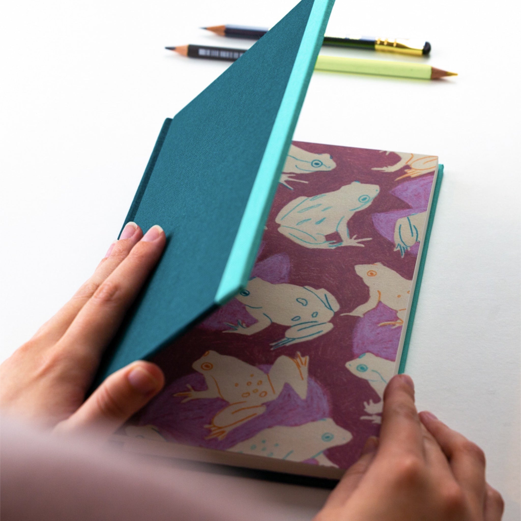 Dark green fabric covered sketchbook with frog pattern end pages