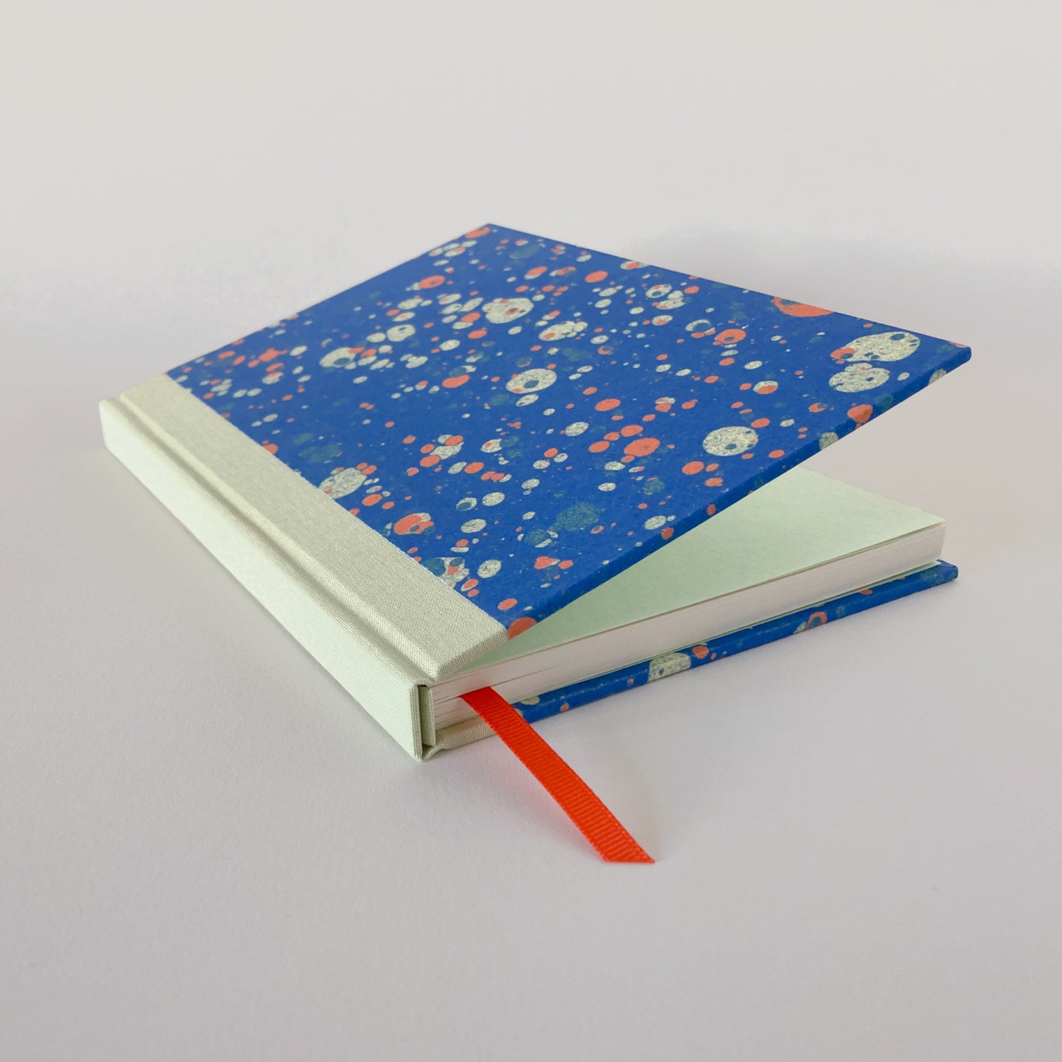 Blue marble hardback notebook partially open, revealing mint end pages.
