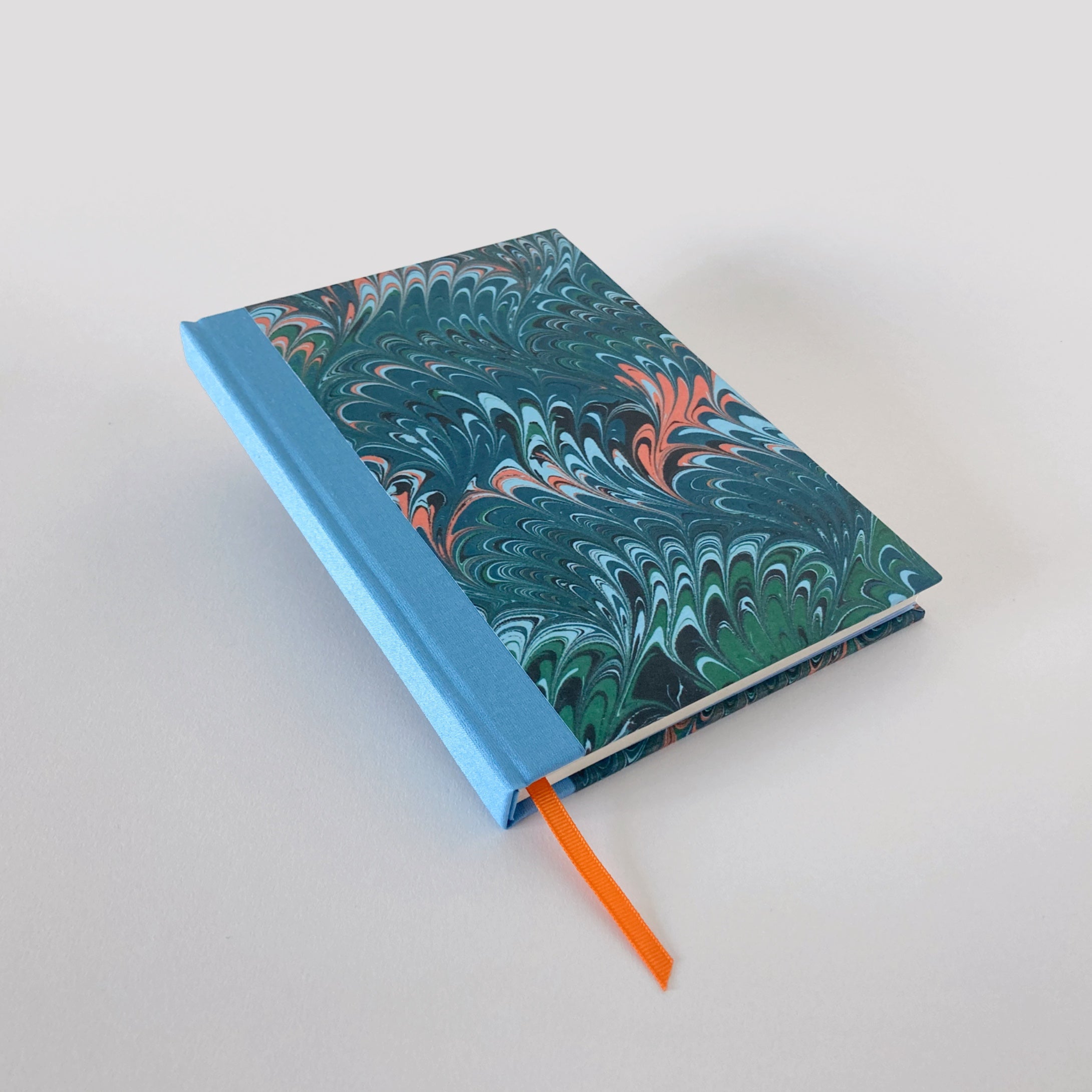 Green marble hardback notebook with blue cloth spine and orange ribbon bookmark.