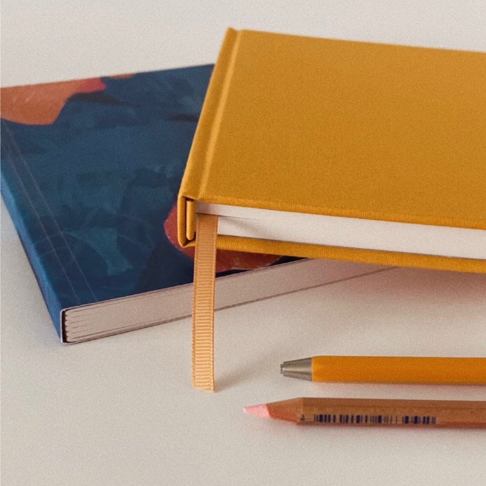 Warm yellow cloth hardback sketchbook with blue paperback sketchbook